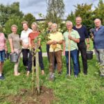 Gemeindevertreter und Einwohner Wittenfördens mit frisch gepflanztem Apfelbaum